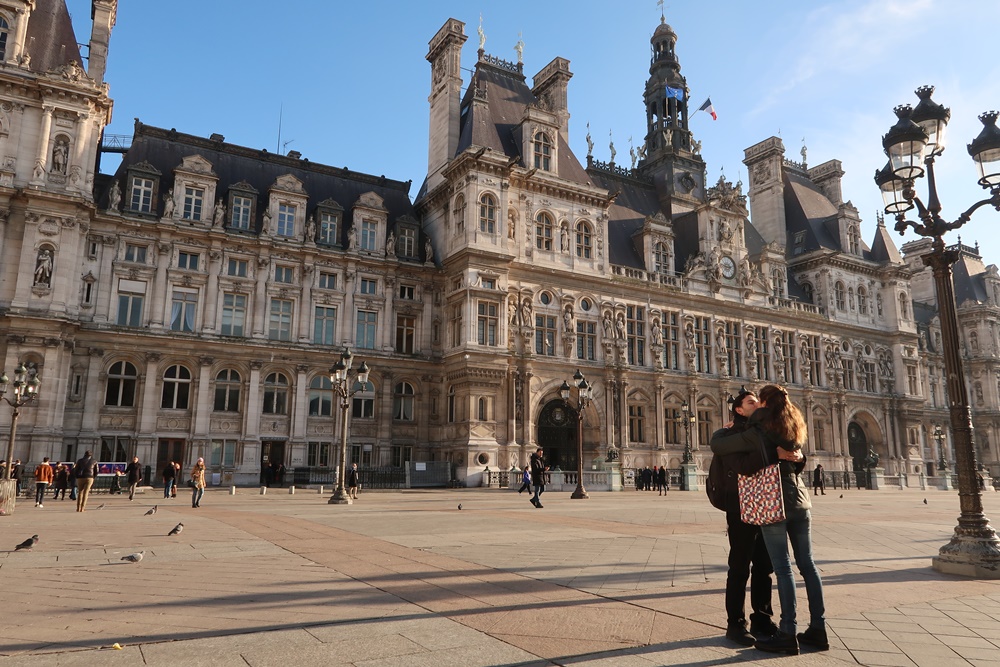 French couple kissing in front of Paris town hall